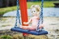 Old abandoned doll on a swing at outdoors Royalty Free Stock Photo