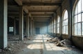 Old abandoned factory building interior. Concrete columns support structure. Large arched windows let in sunlight, casting long Royalty Free Stock Photo