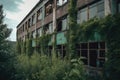 old abandoned factory with overgrown vegetation and broken windows Royalty Free Stock Photo