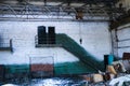 Old, abandoned factory. Scattered glass, iron, wooden remains of the production on the floor, covered with snow and sawdust.