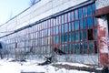 Old, abandoned factory. Scattered glass, iron, wooden remains of the production on the floor, covered with snow and sawdust.