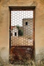 Old abandoned factory seen through rusty metal door