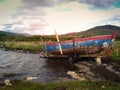 An old abandoned fishing boat in very poor shape waiting for a restoring on the shore of a lake in Ireland Royalty Free Stock Photo