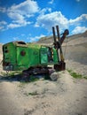 Old and abandoned green large excavator with heavy shovel in limestone quarry. Rusty technique. Back view. Sunny summer day with Royalty Free Stock Photo