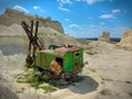 Old and abandoned green large excavator with heavy yellow shovel in limestone quarry. Rusty and broken technique. Back view. Sunny Royalty Free Stock Photo