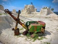 Old and abandoned green large excavator with heavy yellow shovel in limestone quarry. Rusty and broken technique. Front view. Royalty Free Stock Photo
