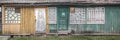 Old abandoned green wooden house facade with many doors and windows Royalty Free Stock Photo