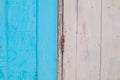 Old abandoned grunge vintage pastel white and red wooden window with blue wall yellow frame fixed with patches of rubber. Royalty Free Stock Photo