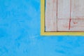 Old abandoned grunge vintage pastel white and red wooden window with blue wall yellow frame fixed with patches of rubber. Royalty Free Stock Photo