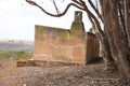 Old abandoned house on farm next to trees.