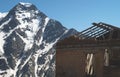 Old abandoned house in the mountains. Ruins of a cottage without a roof on the background of snowy peaks of mountains Royalty Free Stock Photo