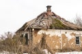 Old abandoned house. Weathered ruined building with broken straw roof. Aged rural home made ofrocks, stone and clay Royalty Free Stock Photo