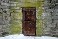 Old abandoned metal door with rust in castle wall