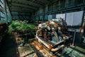 Old abandoned overgrown factory with rusty remains of industrial machinery in workshop Royalty Free Stock Photo