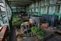 Old abandoned overgrown factory with rusty remains of industrial machinery in workshop Royalty Free Stock Photo