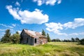 Old abandoned prairie farmhouse surrounded by trees, tall grass and blue sky Royalty Free Stock Photo