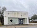 Old abandoned retail building busted window bars on door