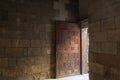 Old abandoned room with stone bricks and grunge weathered wooden decorated door Royalty Free Stock Photo