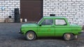 Old abandoned rusted light green colored soviet retro car near auto repair shop ready for tuning.Used second hand car.