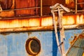 Old abandoned rusted ship moored to the pier in the seaport close up