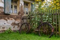 Old abandoned rusty bicycle leaning at a wooden fence in front of an old farm house Royalty Free Stock Photo