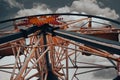 An Old abandoned rusty metal ferris wheel against blue sky. Detailed view of abandoned ferris wheel.