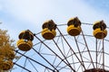 Old abandoned rusty metal radioactive yellow ferris wheel in amusement park in ghost town Pripyat, Chernobyl Exclusion Zone Royalty Free Stock Photo