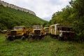 Old abandoned rusty military trucks overgrown by plants