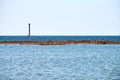 Old abandoned rusty sea pier for mooring boats and yachts on background of calm blue sea, horizon Royalty Free Stock Photo