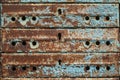 Old abandoned rusty shabby faded blue mailbox with many compartments on the street