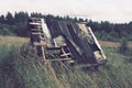 Old abandoned sad well or house in Nyrki village, Karelia. A lopsided wooden roof with slipped roofing material. A field Royalty Free Stock Photo