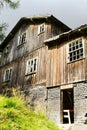 Old abandoned scary wooden house on a forest glade.