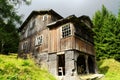 Old abandoned scary wooden house on a forest glade.