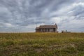 An old, abandoned school house sitting in the middle of the great plains Royalty Free Stock Photo