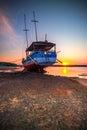 Old abandoned ship on the ocean shore. Broken ship. Sandy beach. Sunset view. Blue sky. Sun on horizon. Vertical layout. Copy Royalty Free Stock Photo