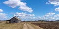 An old abandoned small wooden house in the field blue sky white clouds, barn or scary concept Royalty Free Stock Photo