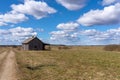 An old abandoned small wooden house in the field blue sky white clouds, barn or scary concept Royalty Free Stock Photo