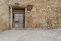 Old abandoned stone bricks wall with broken weathered wooden door