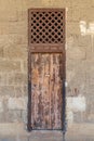 Old abandoned stone bricks wall with weathered wooden door and windows covered with wooden grid, Old Cairo, Egypt Royalty Free Stock Photo