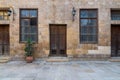 Old abandoned stone bricks wall with wooden doors, windows covered with iron bars and lanterns Royalty Free Stock Photo