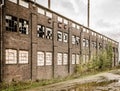 Old abandoned stone building with broken windows and a puddle outside