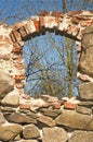 Old abandoned stone and red brick building with hole in the wall where the window was in sunny day Royalty Free Stock Photo