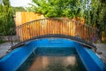 an old abandoned swimming pool with a metal bridge Royalty Free Stock Photo