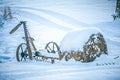 Old abandoned till cultivator covered in snow on farm Royalty Free Stock Photo