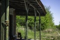 Old abandoned train station. Roof tile gallery for passengers. Train tracks invaded by plants Royalty Free Stock Photo