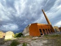 Old abandoned urban industrial complex with high chimney