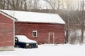 old, abandoned, vintage Red Barn with old car staying next to it. Winter time country scene Royalty Free Stock Photo