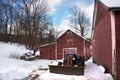 old, abandoned, vintage Red Barn with old rusty tractor staying next to it. Winter time country scene Royalty Free Stock Photo