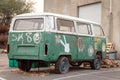 Old abandoned Volkswagen bus spray-painted in a parking lot