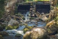 Old, abandoned water mill with water streams and little waterfalls